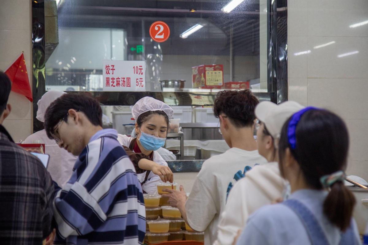 人群中，向点餐的同学递送号码牌（学通社记者 徐剑锋 摄）